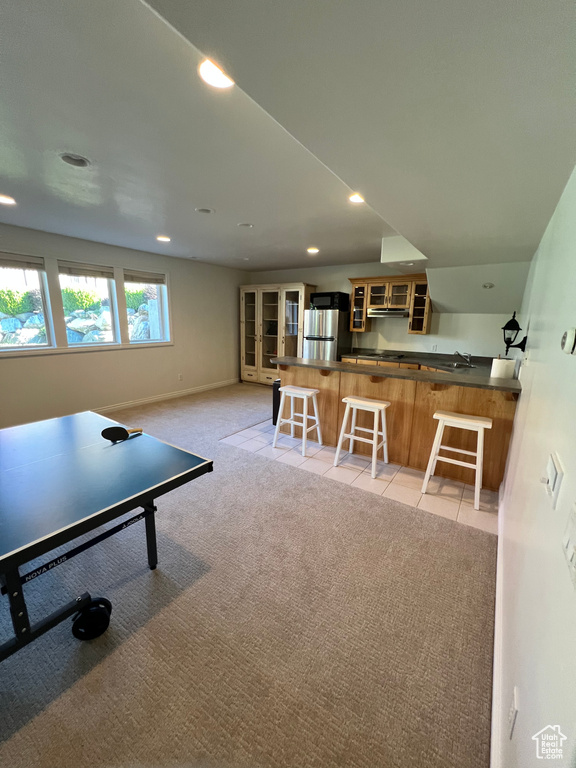 Recreation room with recessed lighting, a sink, baseboards, and light carpet