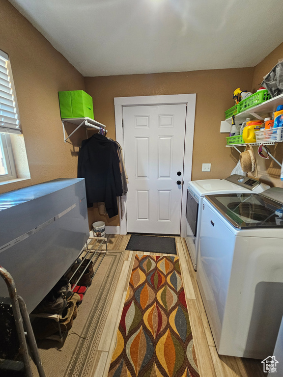 Washroom featuring laundry area, separate washer and dryer, and light wood-type flooring