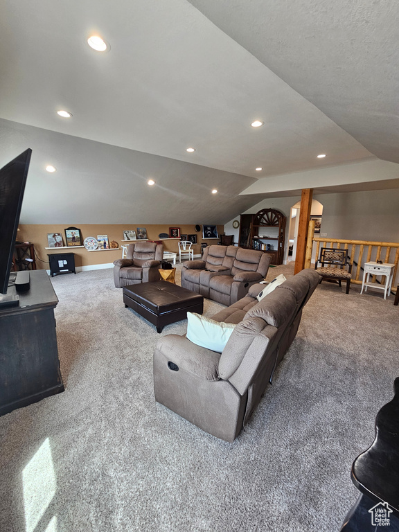 Living area with carpet floors, recessed lighting, and lofted ceiling