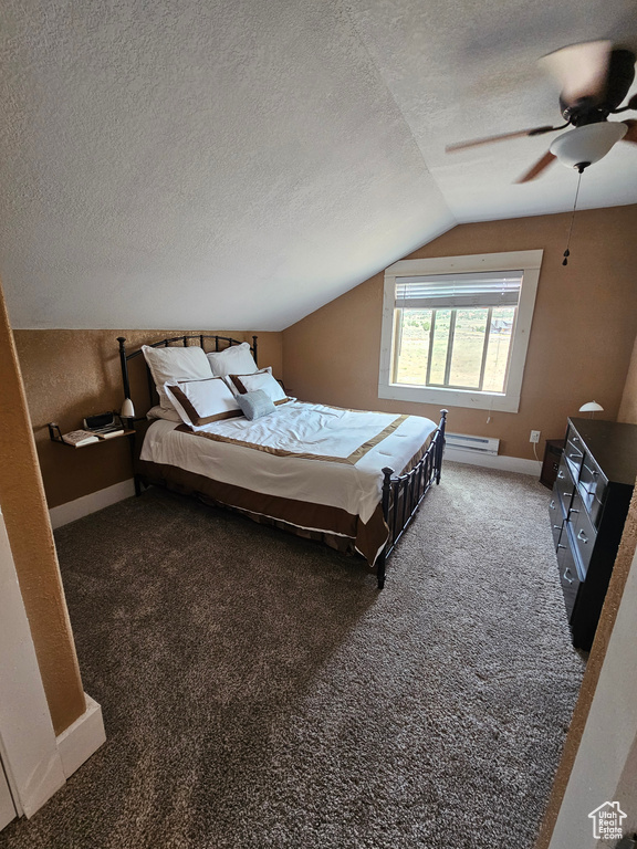 Carpeted bedroom featuring baseboards, baseboard heating, a textured ceiling, a ceiling fan, and vaulted ceiling