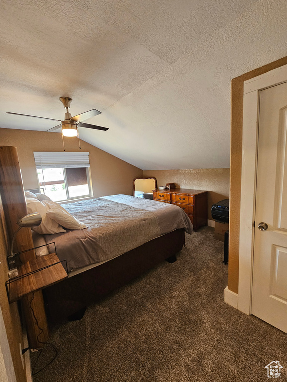 Bedroom with dark colored carpet, a textured ceiling, ceiling fan, and vaulted ceiling