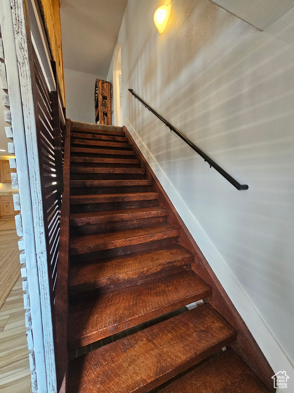 Stairs featuring wood finished floors