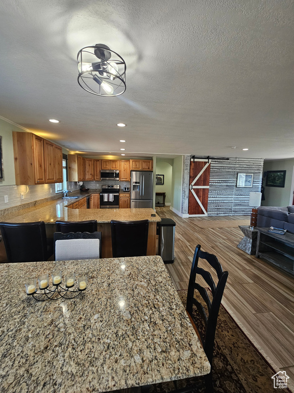 Dining space featuring a textured ceiling, recessed lighting, and wood finished floors