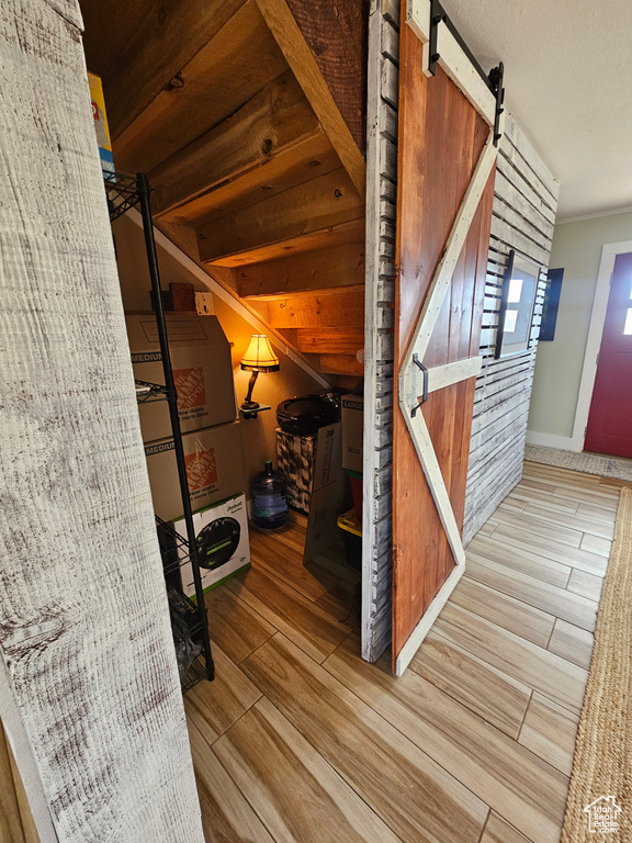 Bonus room featuring a barn door and wood finished floors