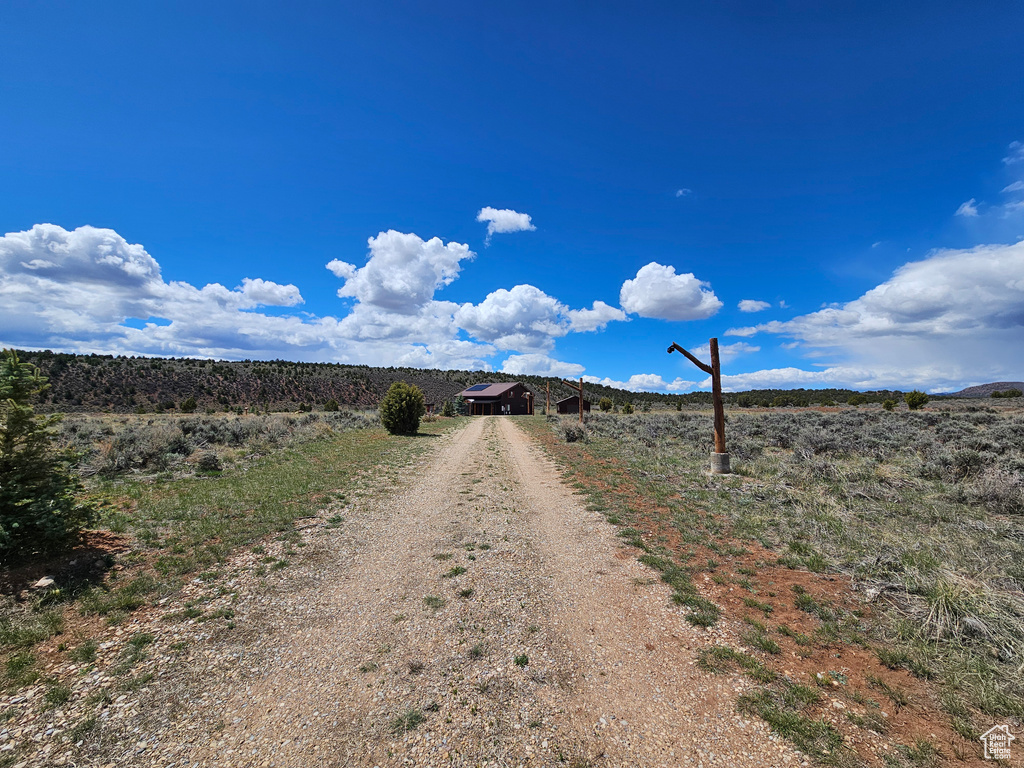 View of street with dirt driveway and a rural view