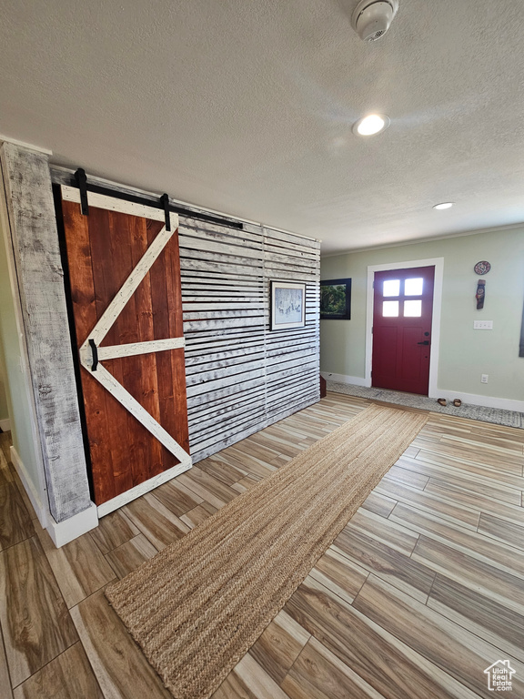 Foyer entrance featuring baseboards, recessed lighting, a textured ceiling, and wood finished floors