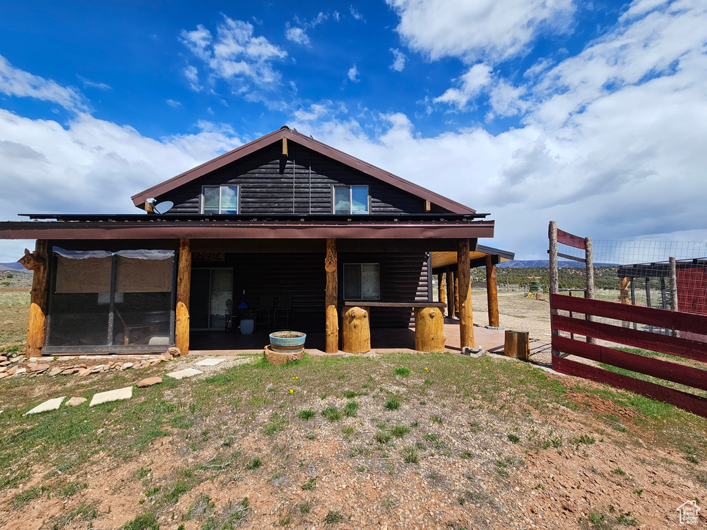 Back of house featuring log veneer siding