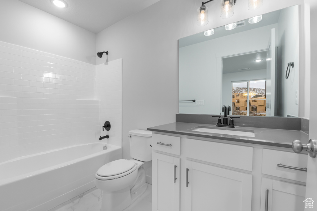 Bathroom featuring vanity, toilet, marble finish floor, recessed lighting, and shower / bath combination