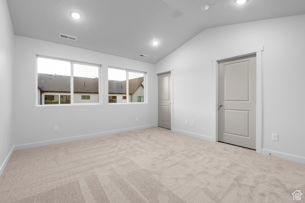 Unfurnished bedroom with baseboards, lofted ceiling, recessed lighting, and visible vents