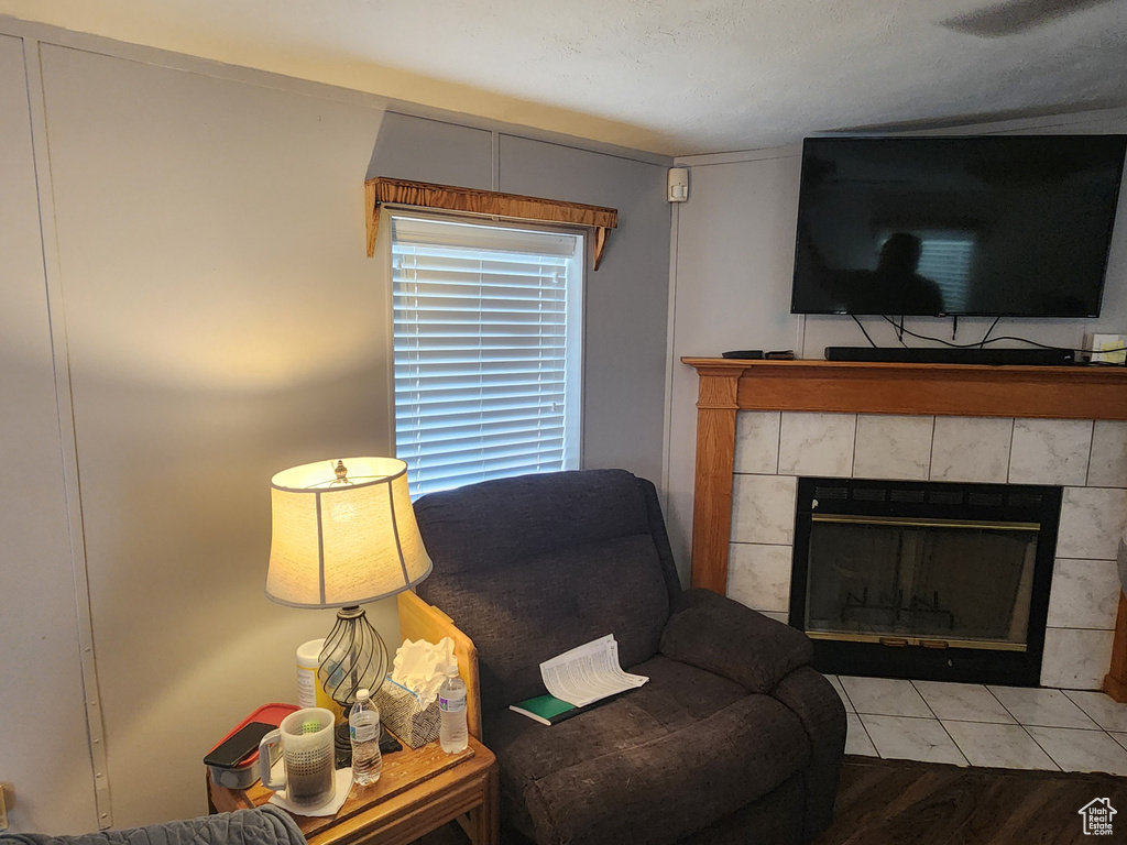 Living area with wood finished floors and a tile fireplace