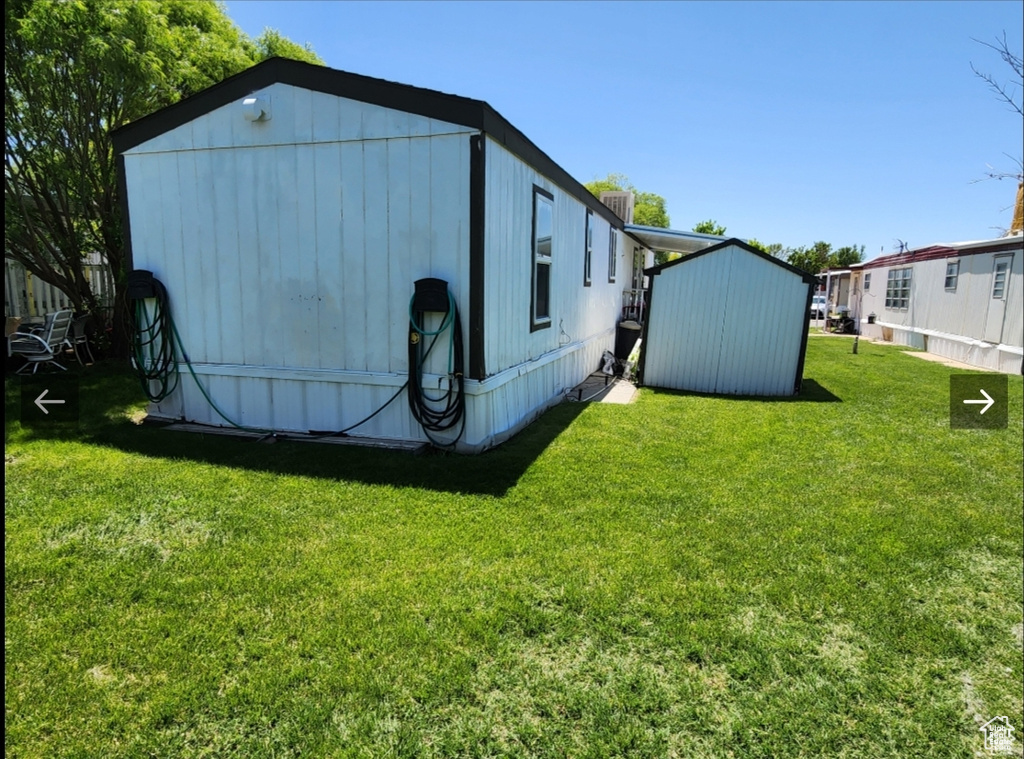 View of home's exterior with a lawn, a storage unit, and an outdoor structure