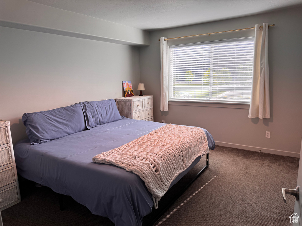 Bedroom featuring carpet and baseboards