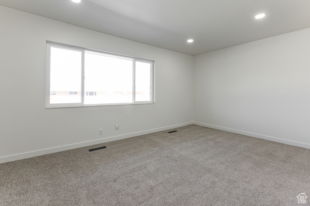 Carpeted empty room with recessed lighting, visible vents, and baseboards