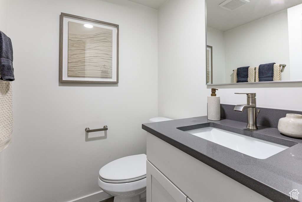 Bathroom with visible vents, vanity, and toilet