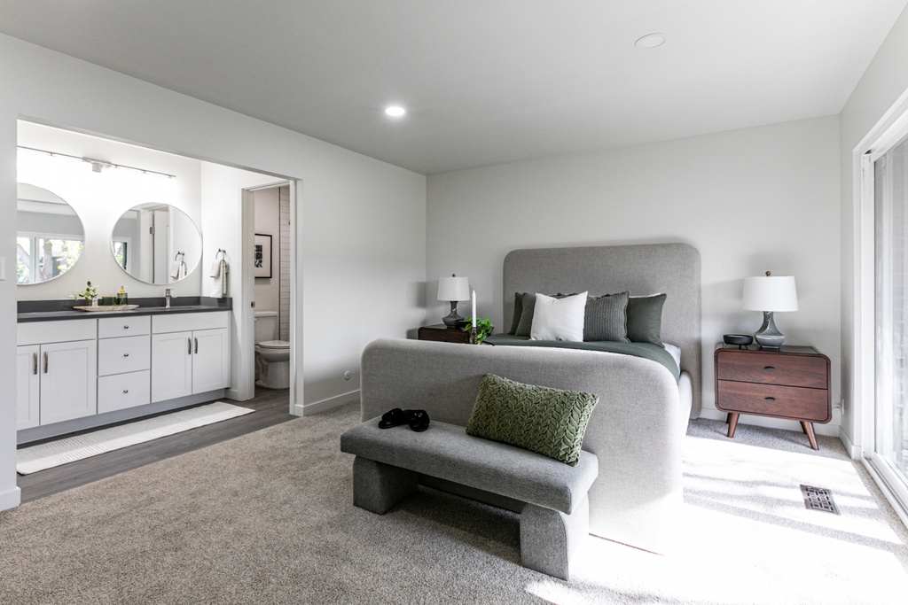 Bedroom with light carpet, a sink, visible vents, indoor wet bar, and ensuite bath