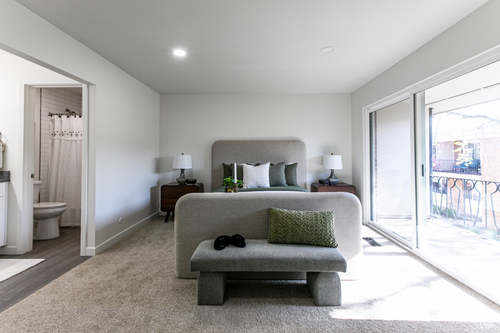 Carpeted bedroom featuring baseboards, ensuite bath, access to outside, and recessed lighting