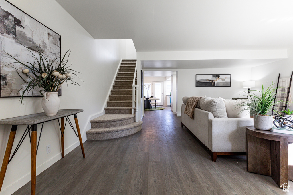 Living area featuring baseboards, wood finished floors, and stairs