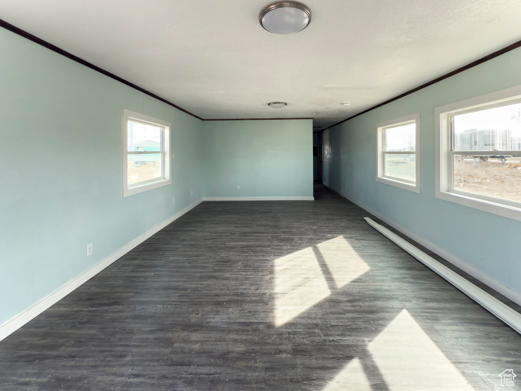 Unfurnished room featuring crown molding, baseboards, and plenty of natural light