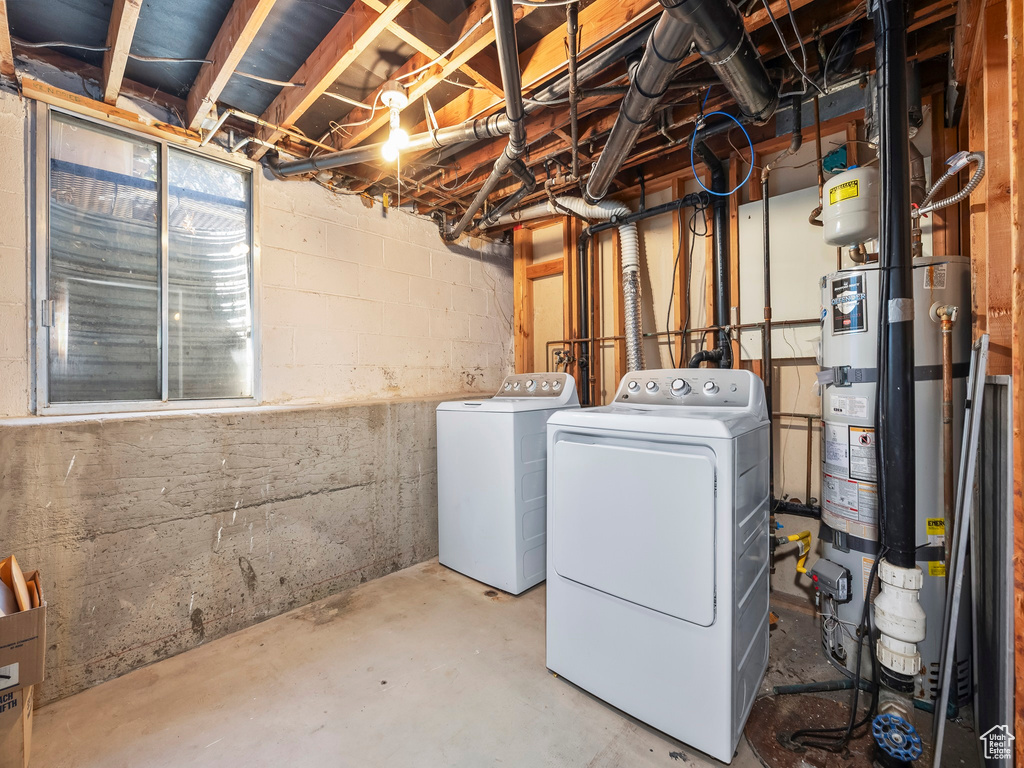 Unfinished basement featuring water heater and washer and dryer