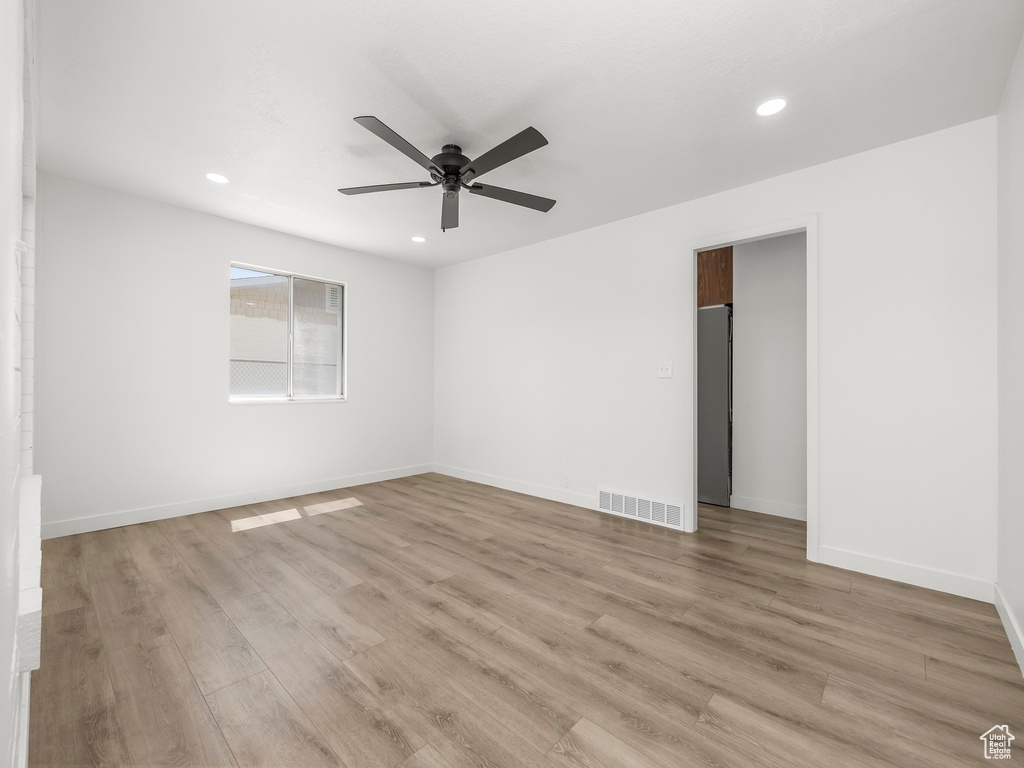 Empty room with light wood-style floors, a ceiling fan, recessed lighting, and visible vents