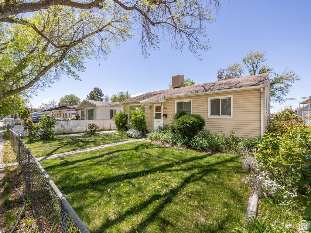 Back of house featuring fence, a chimney, and a yard