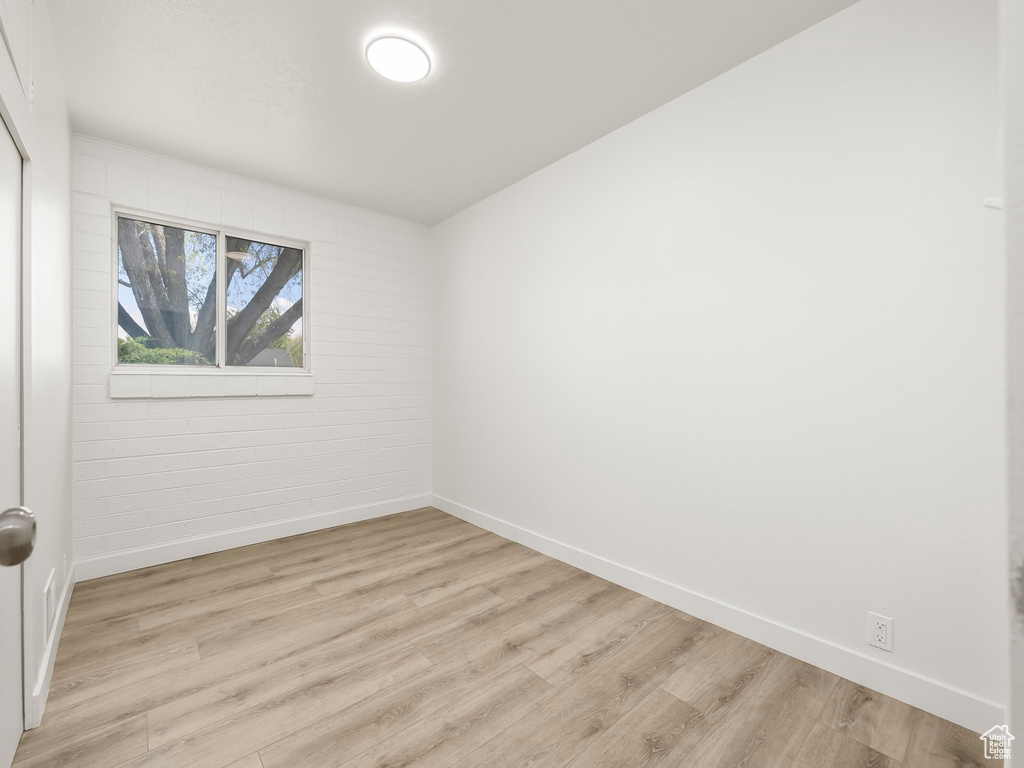 Empty room with baseboards and light wood-type flooring