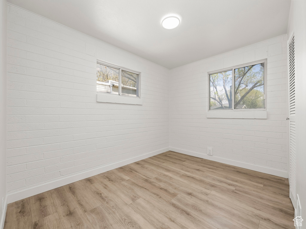 Empty room featuring baseboards and light wood-style flooring