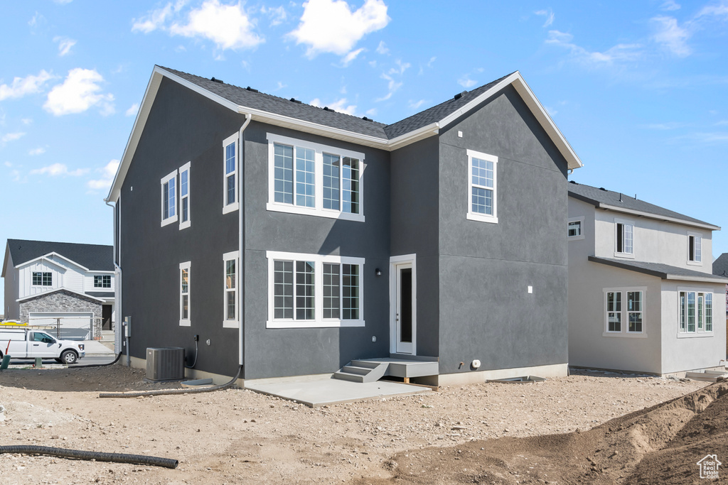 Rear view of house with central AC unit and stucco siding
