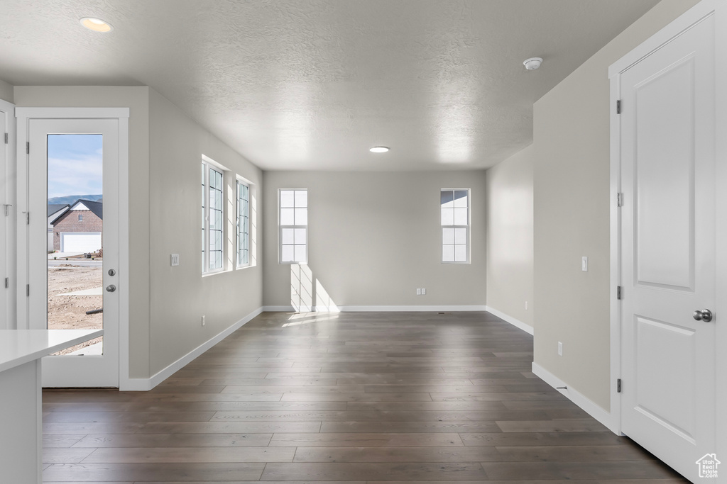 Interior space with baseboards, recessed lighting, a textured ceiling, and dark wood-type flooring