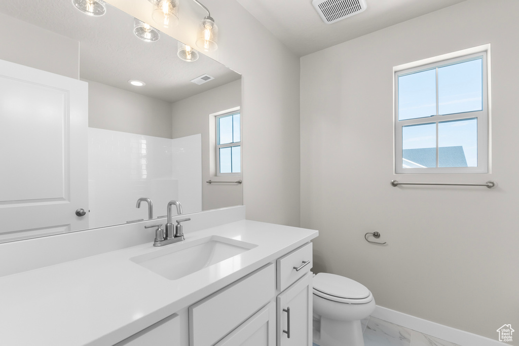 Full bathroom featuring vanity, toilet, marble finish floor, and visible vents