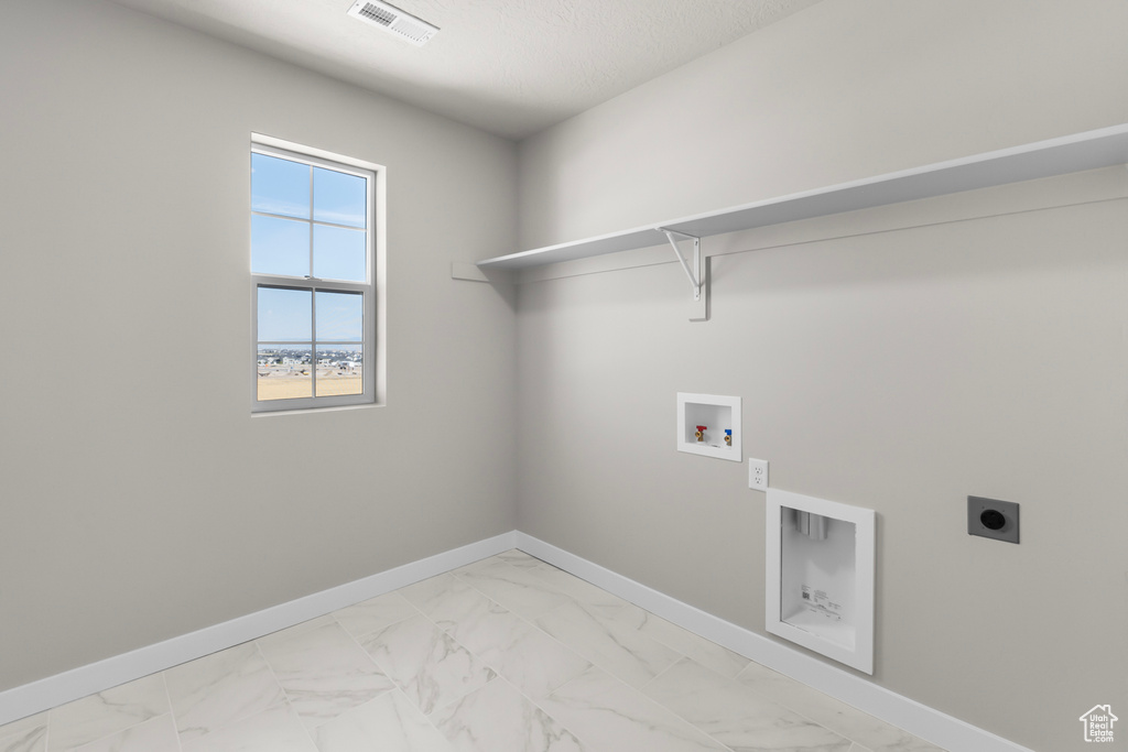 Clothes washing area featuring laundry area, visible vents, marble finish floor, baseboards, and electric dryer hookup