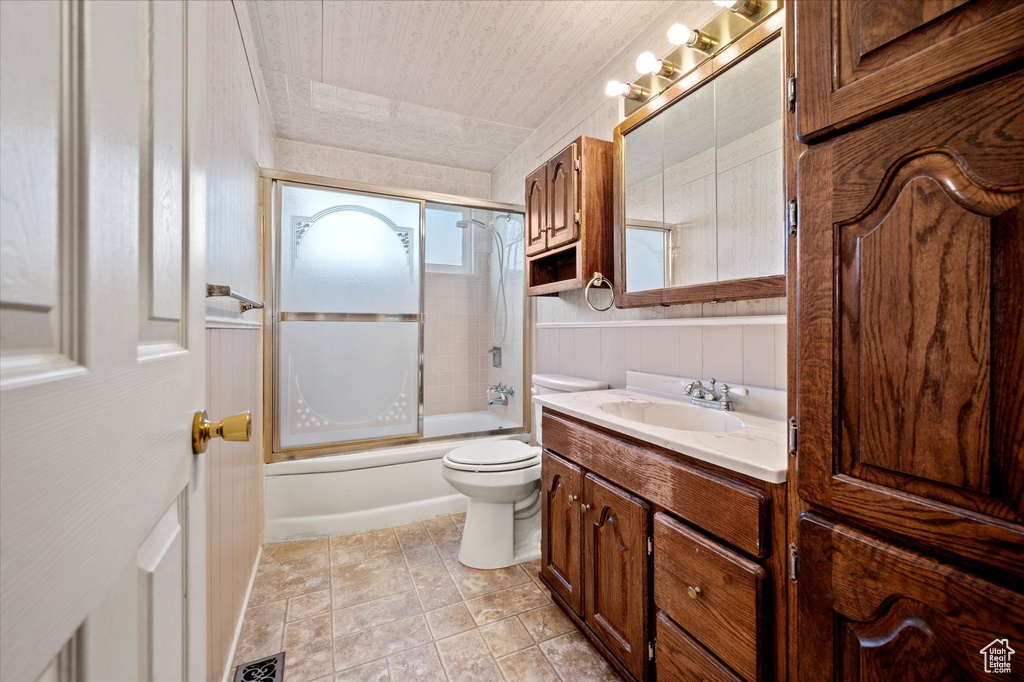 Bathroom with vanity, shower / bath combination with glass door, visible vents, and toilet