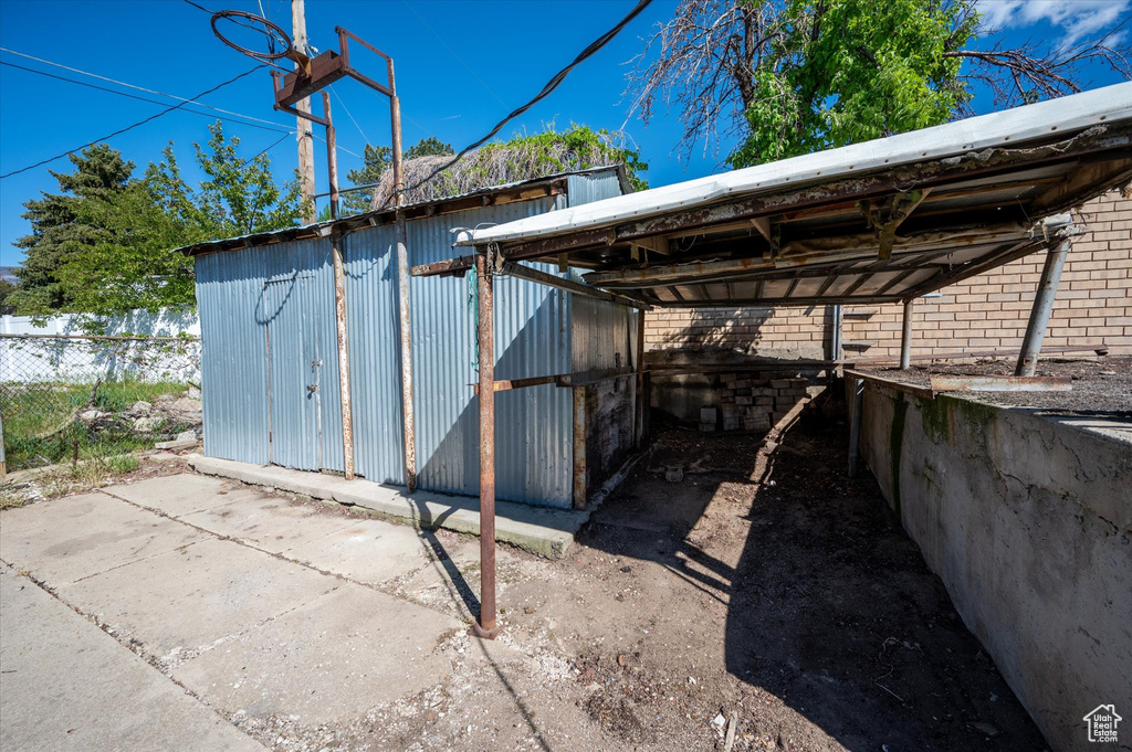 View of outbuilding with fence and an outbuilding