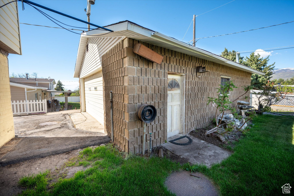 View of outdoor structure featuring driveway, fence, and an outdoor structure