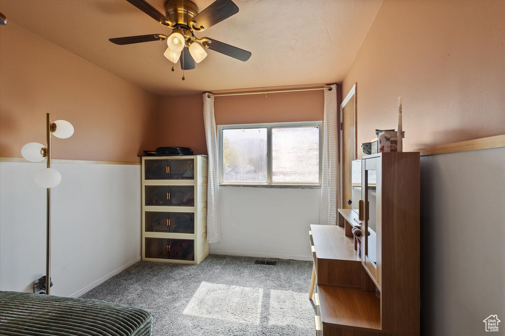 Carpeted bedroom with baseboards and a ceiling fan
