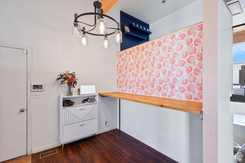 Kitchen featuring baseboards, visible vents, dark wood-type flooring, and a notable chandelier
