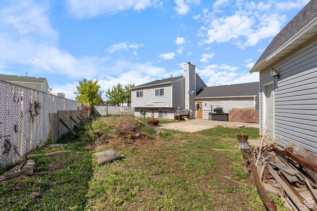 View of yard with fence and a patio area