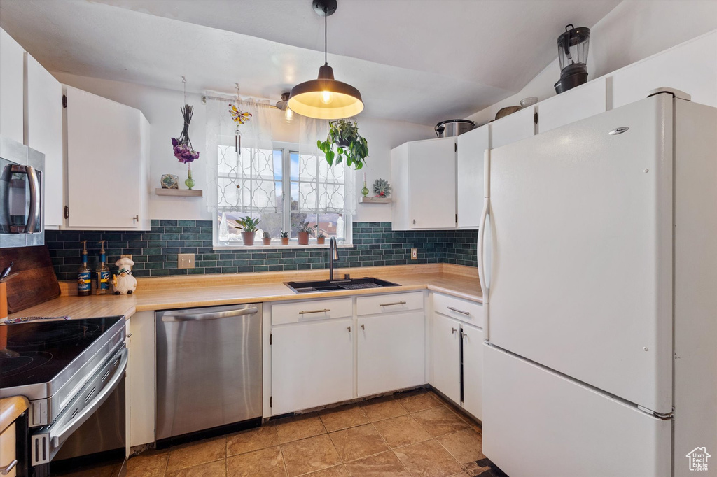 Kitchen featuring open shelves, a sink, light countertops, stainless steel appliances, and tasteful backsplash
