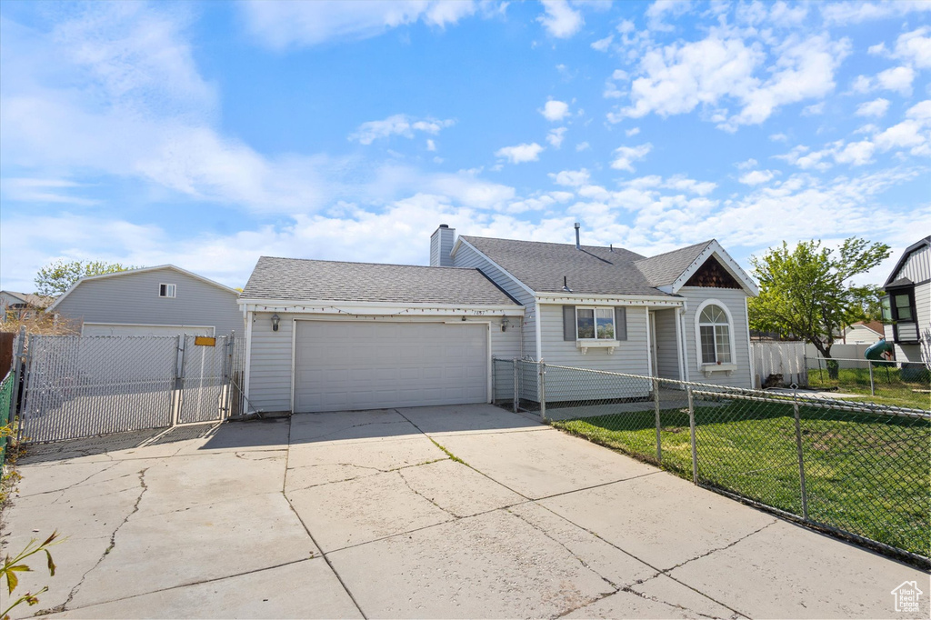 Ranch-style house featuring fence private yard, a gate, a garage, a front lawn, and concrete driveway