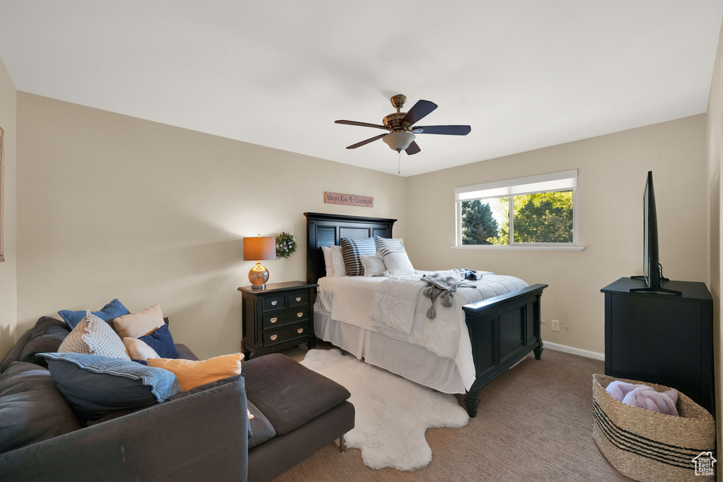 Bedroom with ceiling fan, baseboards, and light carpet
