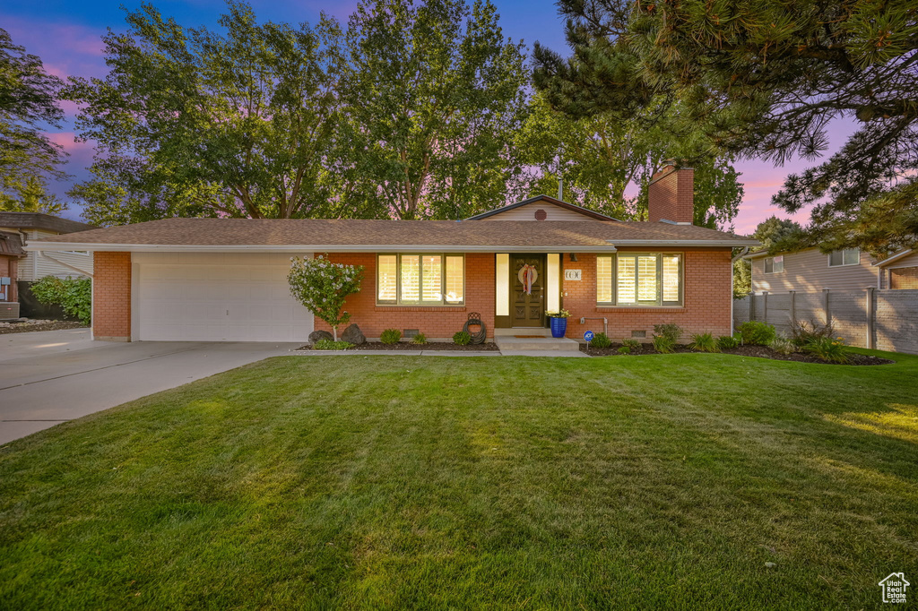 Ranch-style house featuring driveway, a chimney, fence, brick siding, and a garage