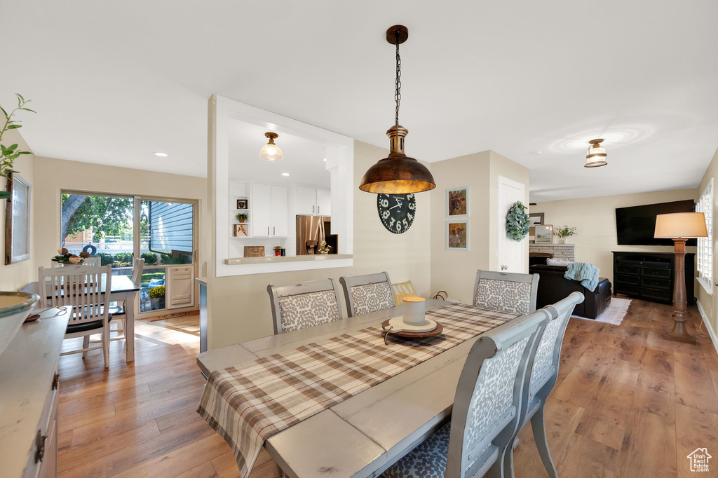 Dining room featuring recessed lighting, light wood-style floors, and a fireplace