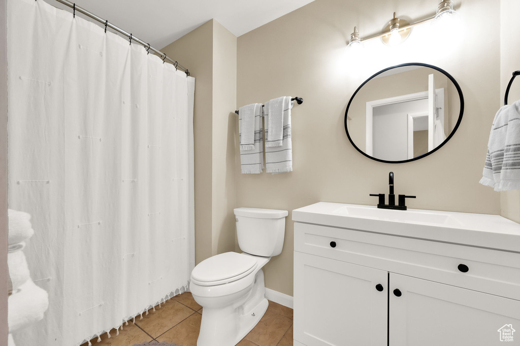 Full bathroom featuring vanity, toilet, tile patterned flooring, and baseboards