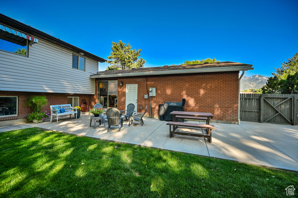 View of patio / terrace featuring fence, a gate, area for grilling, and a mountain view