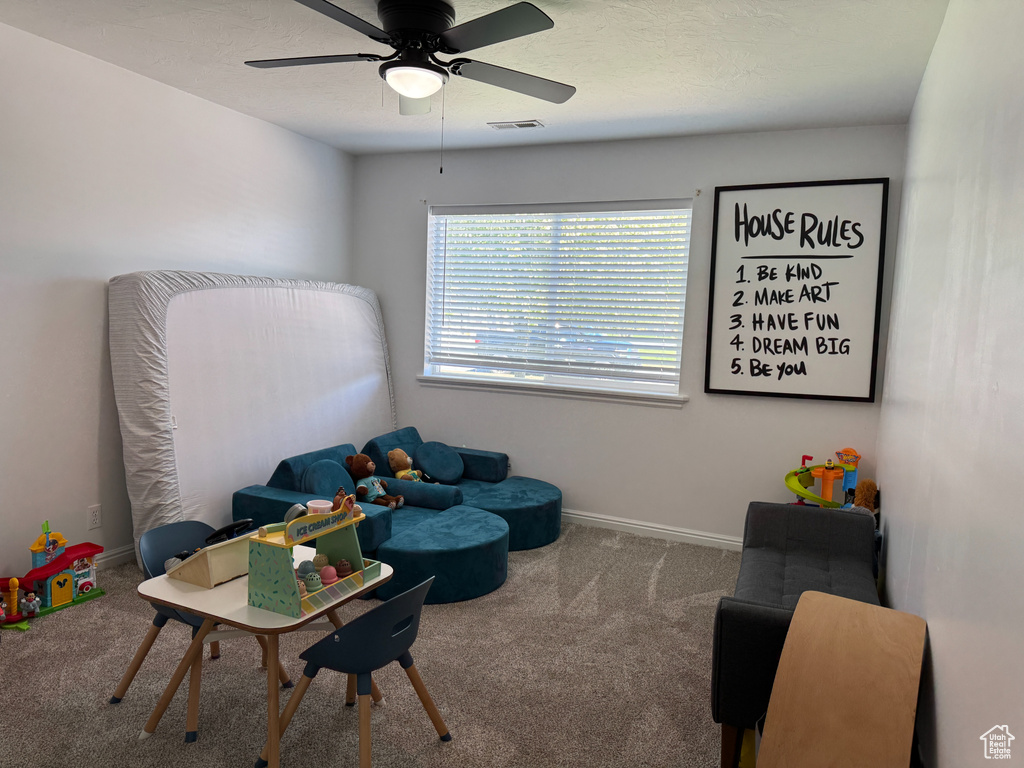 Playroom featuring carpet floors, ceiling fan, visible vents, and baseboards