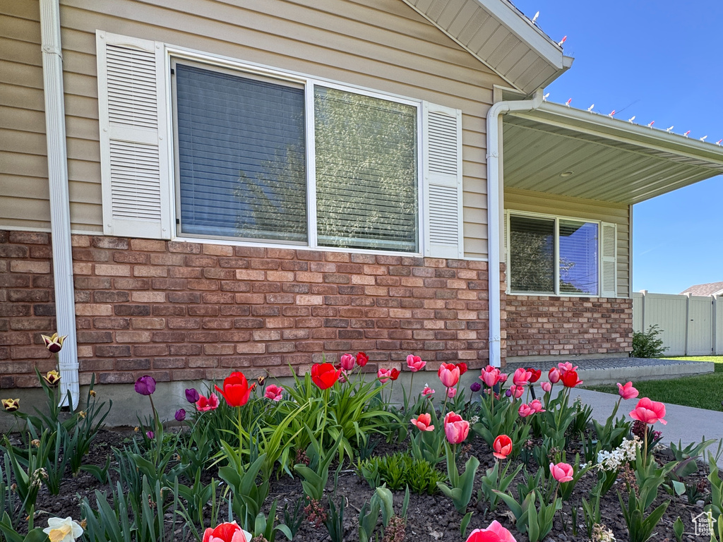 View of property exterior with brick siding and fence