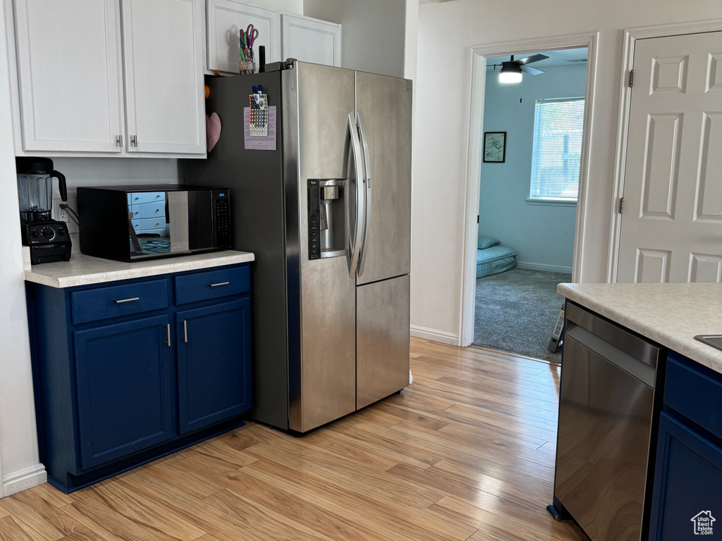 Kitchen featuring blue cabinetry, visible vents, appliances with stainless steel finishes, light countertops, and light wood-style floors