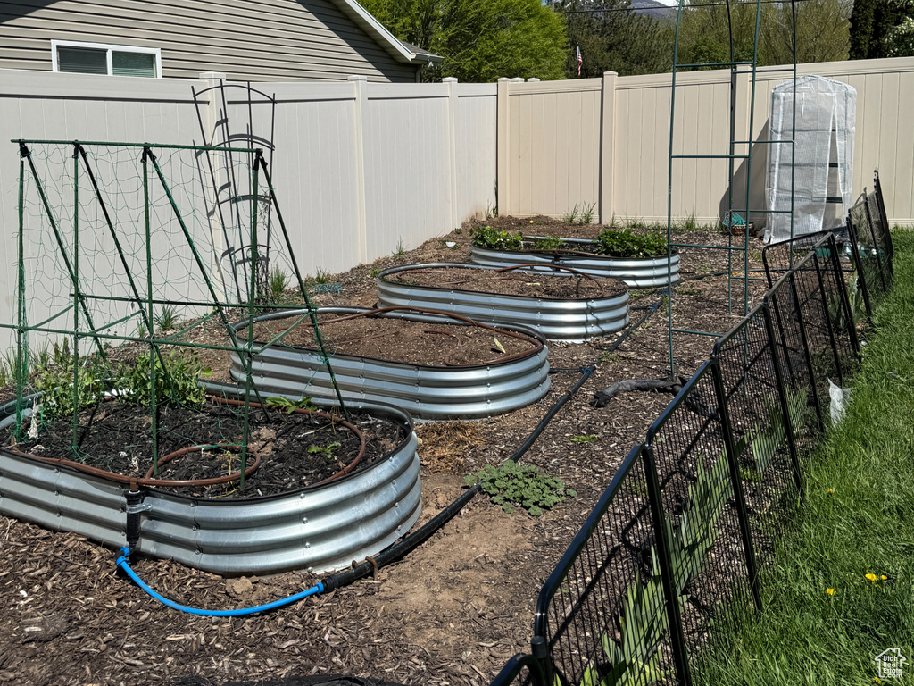 View of yard featuring fence and a garden