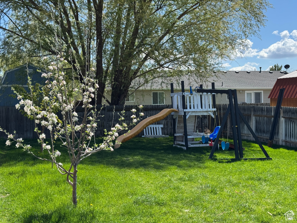 View of jungle gym featuring a fenced backyard and a lawn