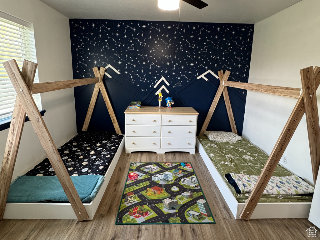 Unfurnished bedroom featuring visible vents, an accent wall, and wood finished floors